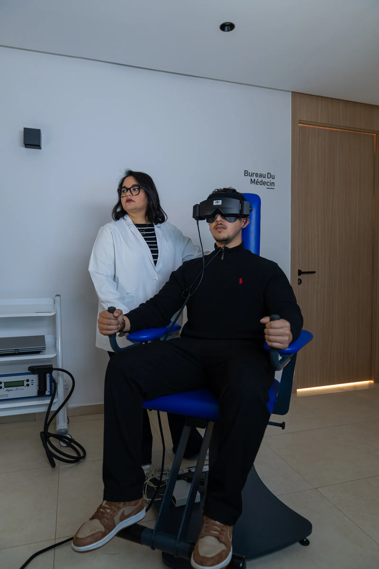 Dr Sara Rochd auprès d’une personne installée pour une exploration vestibulaire